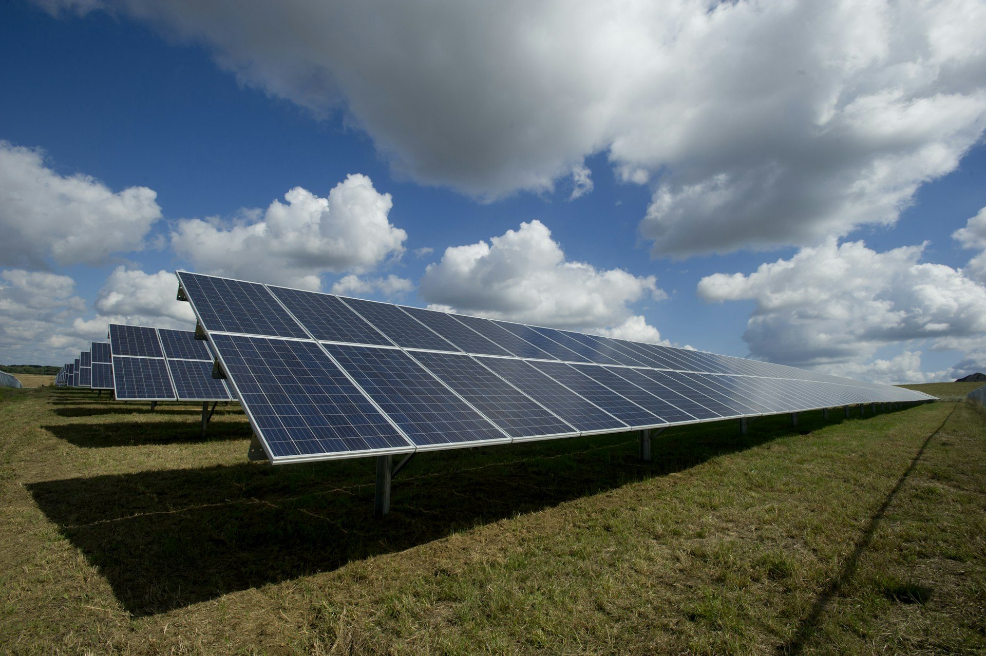 Ground-mounted solar array on a rural property under a blue sky