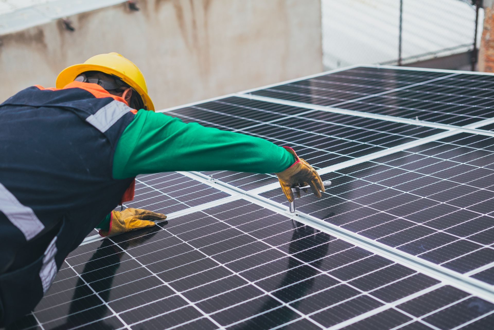 Licensed installer in hard hat working on a rooftop solar system