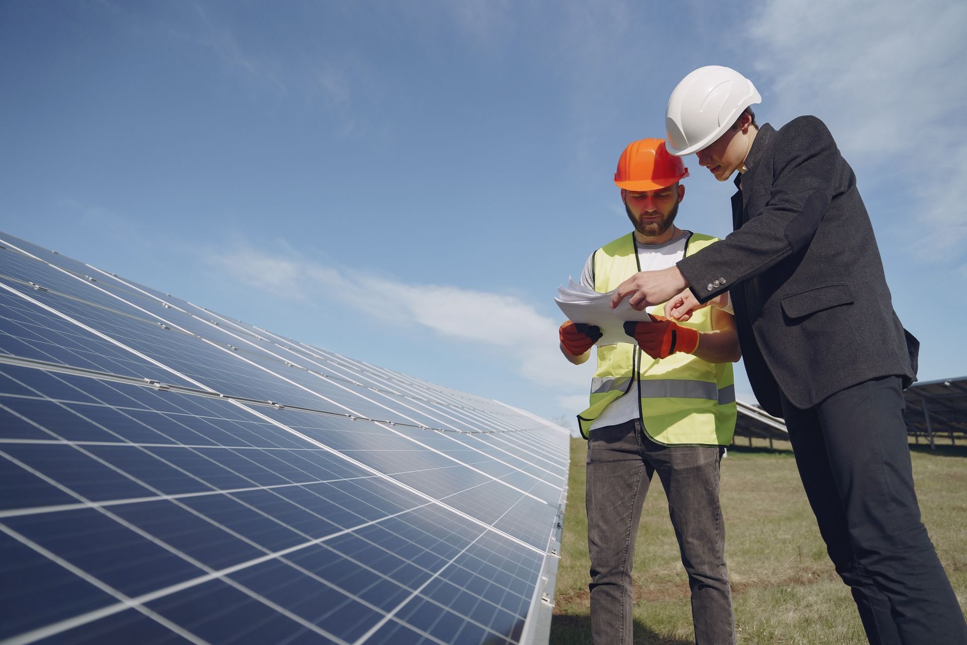 Solar engineer and client reviewing plans beside a solar array
