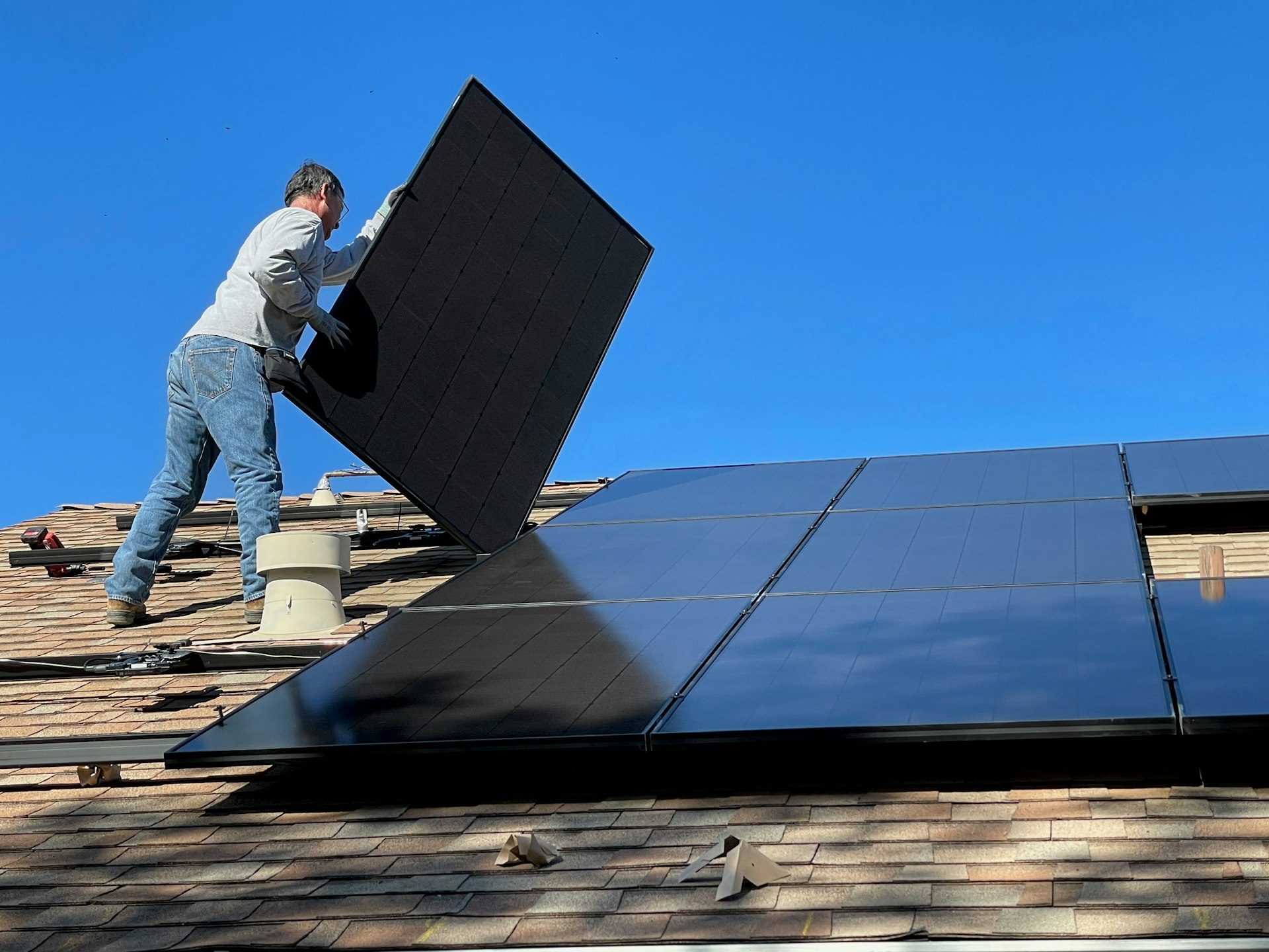 Solar installer fitting panels on a residential roof